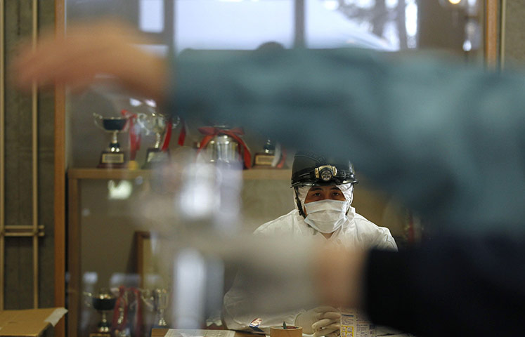 Fukushima disaster: 12 April: A member of Japan's Self-Defence Force watches test for radiation