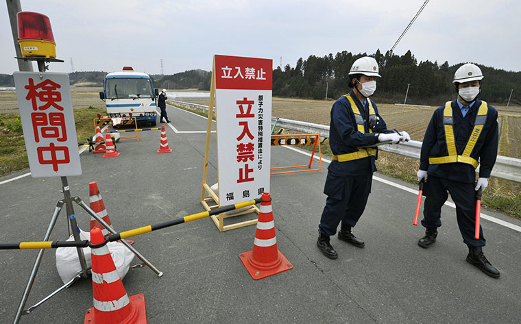 Fukushima disaster: 11 April: Police officers man a checkpoint in Minamisoma