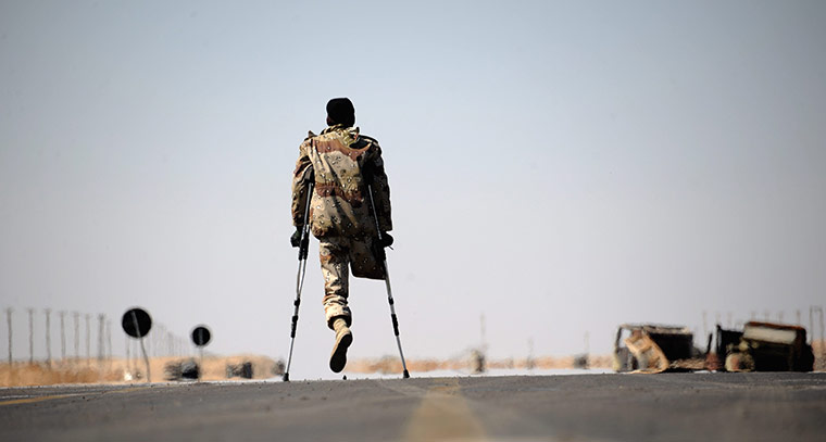Ajdabiya, Libya : A one-legged Libyan rebel fighter walks on the road, Ajdabiya