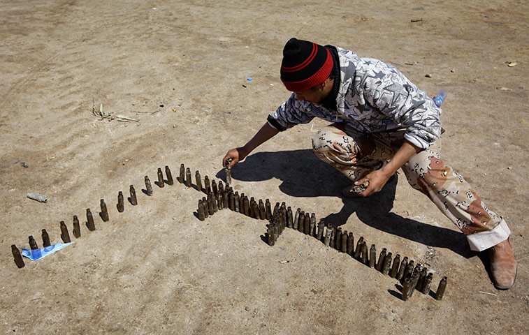 Ajdabiya, Libya : A rebel makes the Arabic word for 