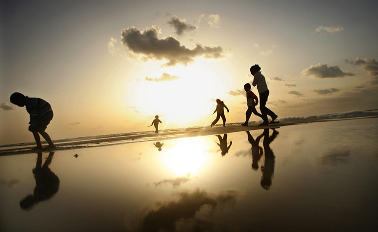 24 hours in pictures: alestinian children play on the  beach at sunset in Gaza