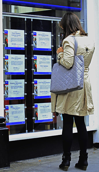 Week in Business: A woman reads notices for jobs at a recruitment agency in London