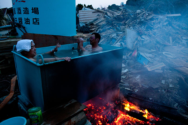 24 hours in pictures: Residents take an out door bath amongst tsunami devastation in Japan 