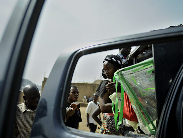 24 hours: Jos, Nigeria: A polling official hangs off the side of a vehicle
