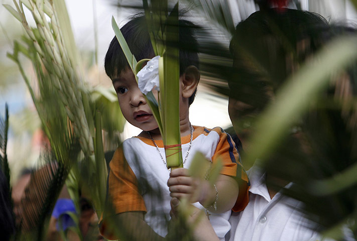24 hours: Manila, Philippines: A boy holds a palm during Palm Sunday