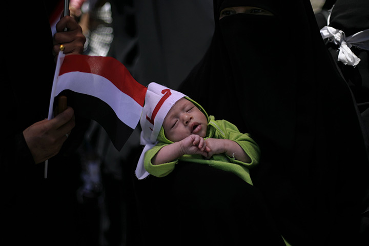 24 hours in pictures: An anti-government protestor holds her baby during in Yemen