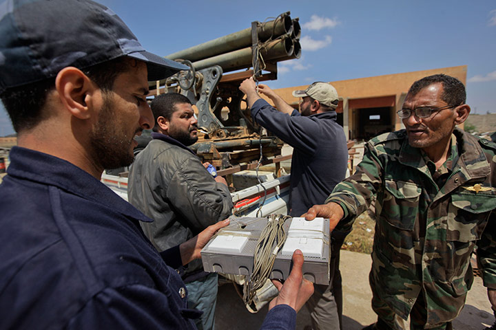 Libyan rebel workshop: Workmen install a firing control mechanism 