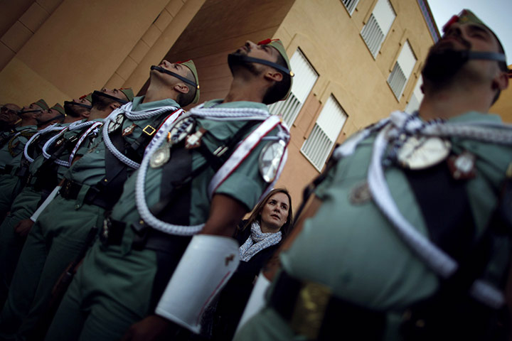 Holy Week in Malaga: A woman watches a statue of Christ behind honour guards