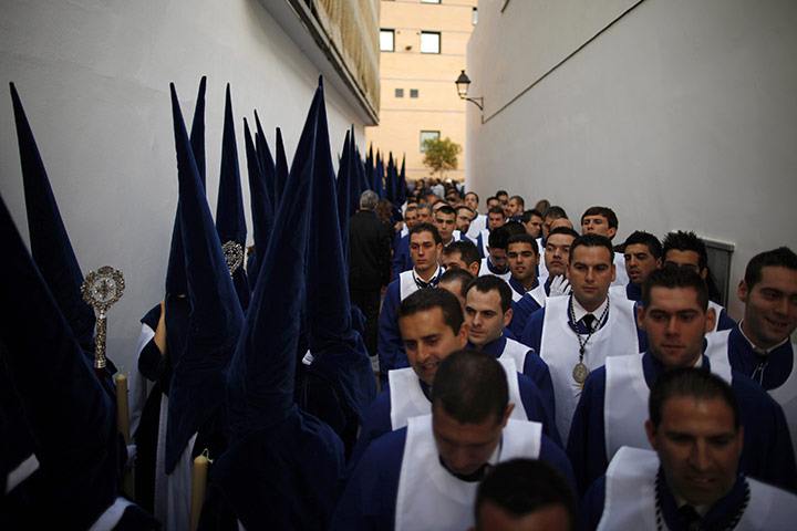 Holy Week in Malaga: Penitents walk to a church before they take part in a procession