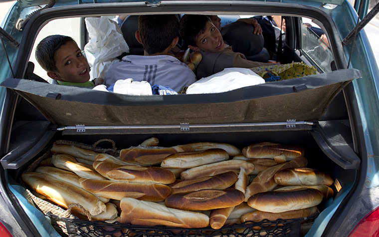 Life in masrata libya: The boot of a car is filled with the bread rations