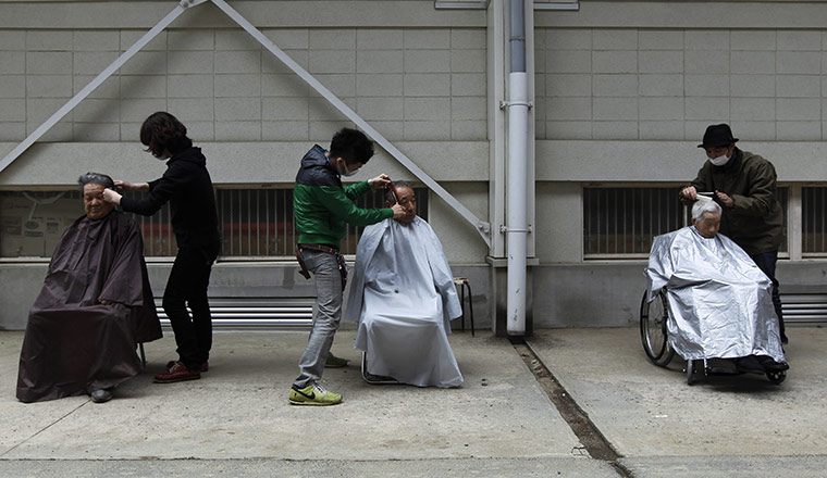 24 hours in pictures: Men get haircuts from volunteer hairdressers