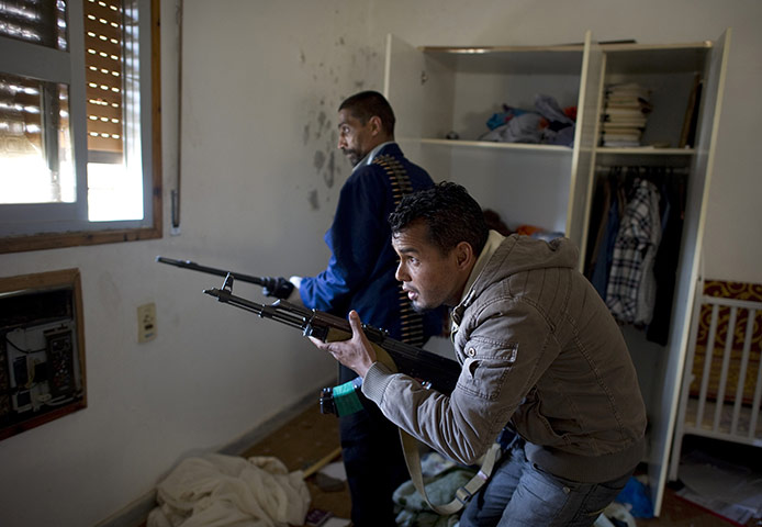 Misrata, Libya update: Two rebel fighters peak out a window, Misrata