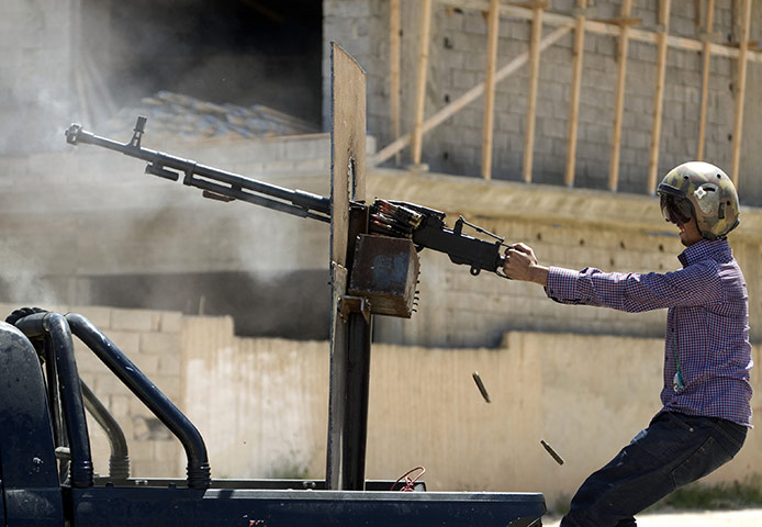 Misrata, Libya update: A Libyan rebel wearing a pilot's helmet fires a heavy machine gun