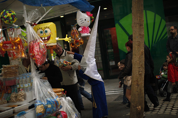from the agencies: A penitent stands next a kiosk of toys during Holy Week in Malaga
