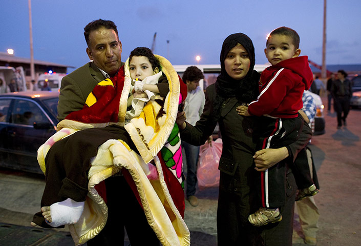 Misrata: In pictures: A family with a wounded child walk towards a ferry