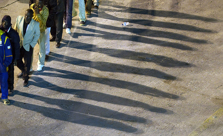 Misrata, libya:: Sub-Saharan African nationals wait to board an ferry 