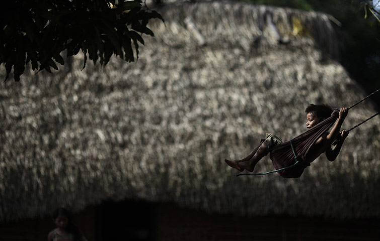 24 Hours: A boy of Kayapo tribe plays in front of his house