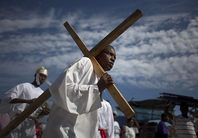 24 Hours: An actor representing Jesus Christ carries a wooden cross in Port-au-Prince