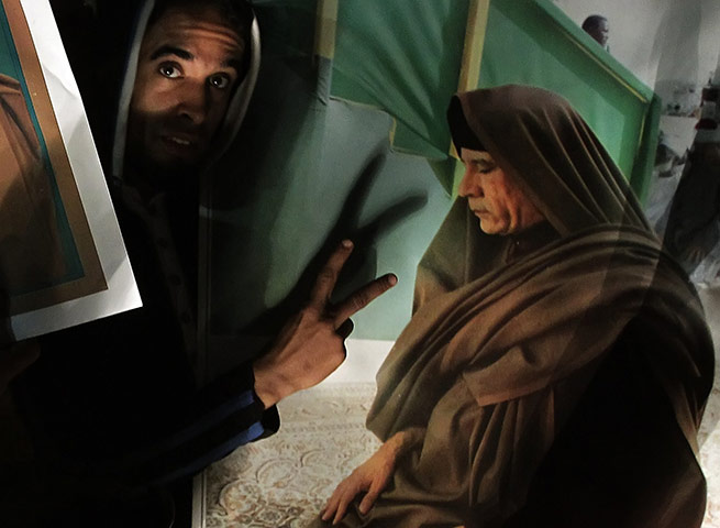 24 hours in pictures:  A supporter of Muammer Gaddafi during a rally 