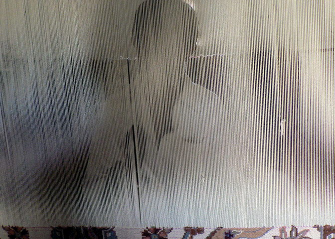 24 hours: A weaver makes a carpet at a  loom at his home in Pakistan