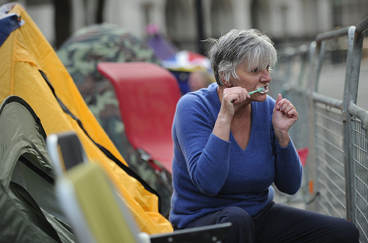 Royal Wedding rehearsal: royal fan brushes her teeth as she camps outside London's Westminster Abbey