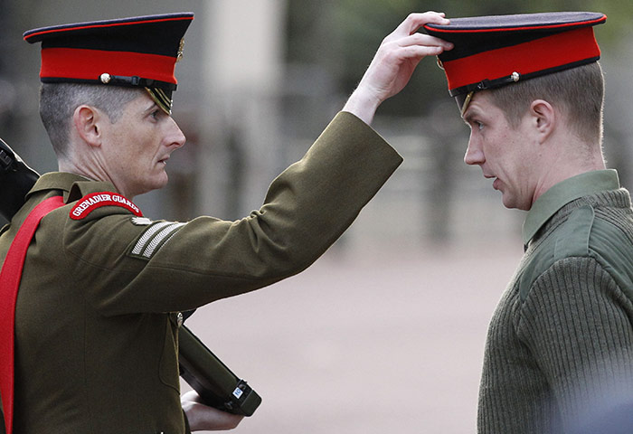 Royal Wedding rehearsal: An officer from the Grenadier Guards adjusts a soldier's cap
