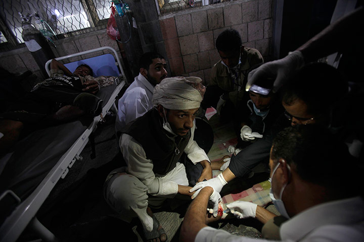 24 hours in pics: A Yemeni doctor uses the light of his mobile phone to help other doctors
