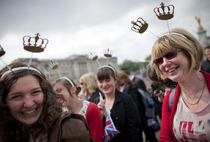 Preparations for wedding: Tourists wear souvenir crowns outside Buckingham Palace