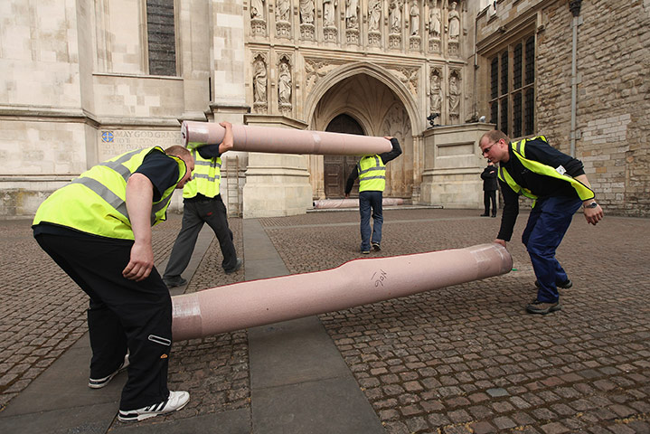 Preparations for wedding: Workers carry in sections of the red carpet at Westminster Abbey 