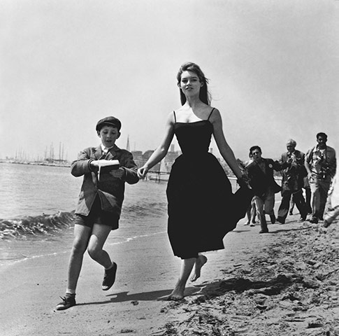 Cannes: Brigitte Bardot with a schoolboy in tow, 1955