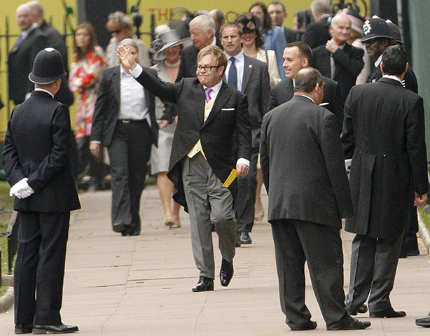 Wedding guests: Sir Elton John waves as he arrives at Westminster Abbey 