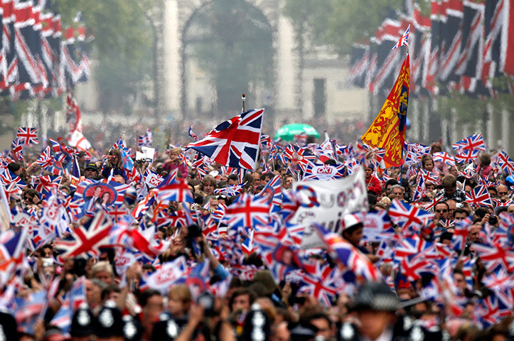 Wedding procession: Wellwishers with flags surge along the Mall 