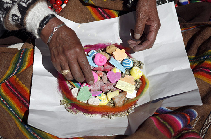 24 hours in pictures: A shaman prepares offerings to the Mother Earth or Pachamama 