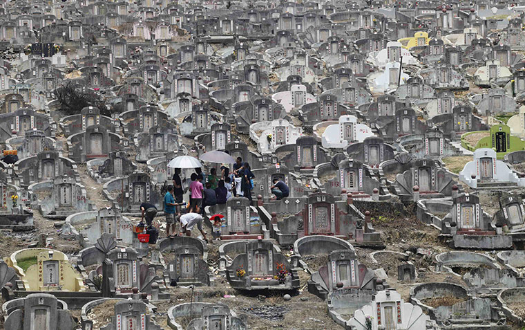 24 hours in pictures: Petaling Jaya, Malaysia: A family gather to offer prayers at a cemetery