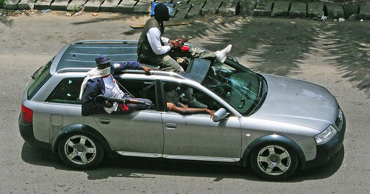 Ivory Coast Abidjan: 1 April: Militants drive a vehicle along a street in Abidjan