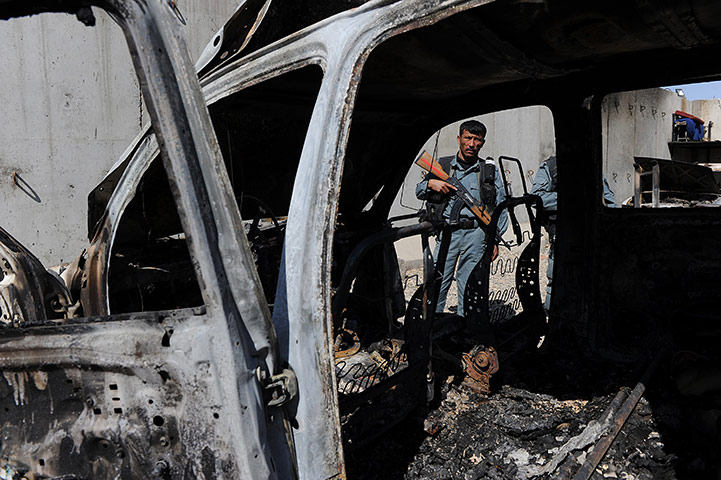 Afghanistan protests: An Afghan policeman stands guard in the compound compound in Mazar-e-Sharif