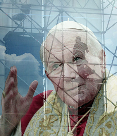 24 Hours: A giant picture of late John Paul II hangs from a stage set in Rome