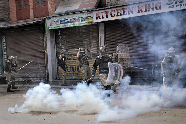 24 Hours: Indian paramilitary soldiers take cover amid tear gas in Srinagar