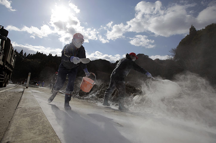 24 hours in pictures: Otsuchi, Japan: Volunteers scatter caustic lime in tsunami devastated area
