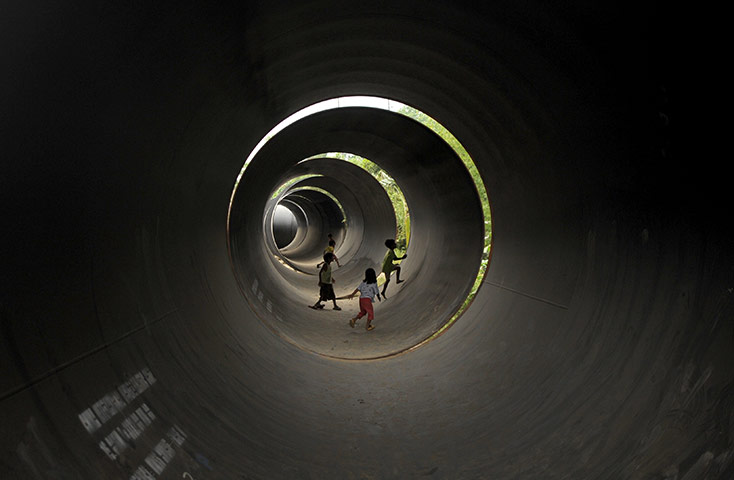 24 hours in pictures: Manila, Philippines: Children play inside steel pipes