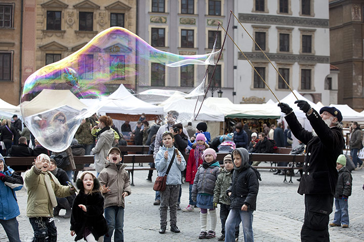 David Levene Poland: A street performer creates huge bubbles in a square in the Old Town