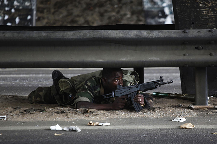 David Levene Poland: A soldier loyal to Ouattara lies on a road as fighting flares in Abidjan