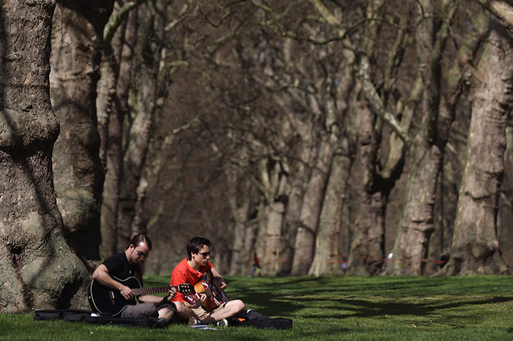April Hot Weather: Two young men play guitars in Hyde Park