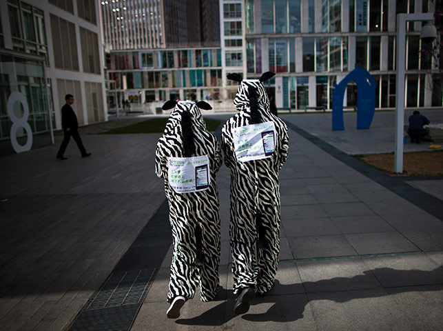 24 hours in pictures: Two workers in animal costumes, Beijing, China