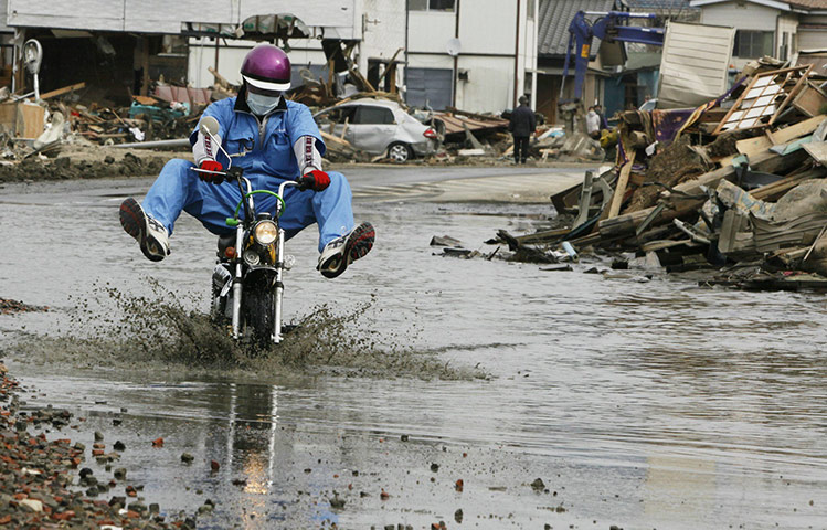 24 hours in pictures: A man rides a motorcycle through Ishinomaki, Japan
