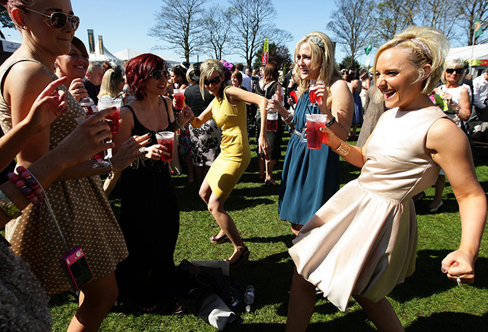 April Hot Weather: Female racegoers dance to music in the sunshine at Aintree
