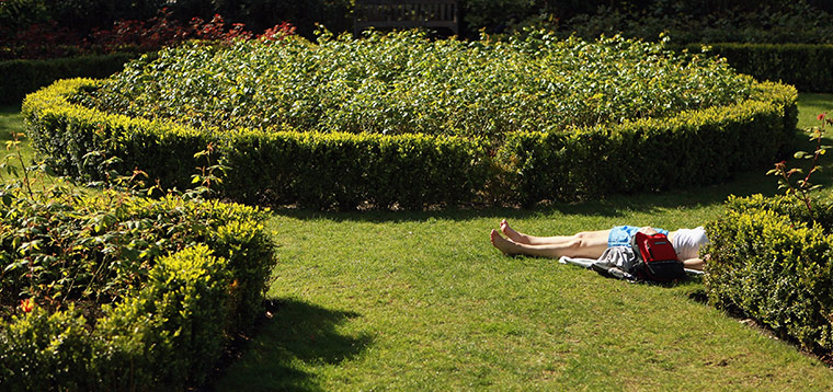 April Hot Weather: A woman relaxes in the sunshine in Rembrandt Gardens, Little Venice