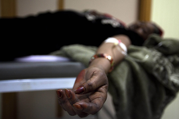 24 Hours in Pictures: A woman receives assistance after arriving at Lampedusa