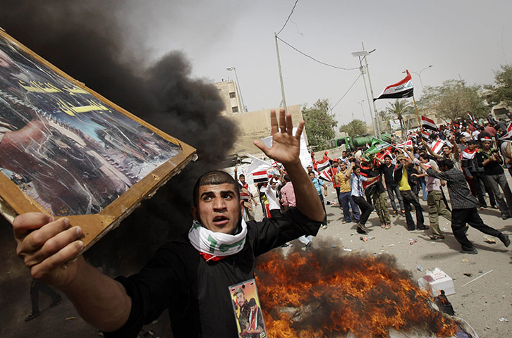 24 Hours in Pictures: Followers of radical Shiite cleric Muqtada al-Sadr burn US flags
