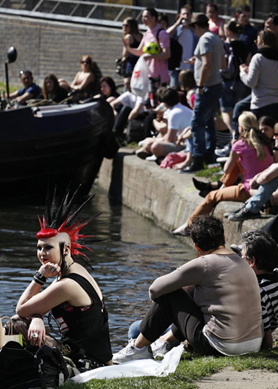 UK Weather: People sit in the sunshine at Camden Lock in London